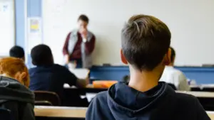 Skolēni mācību stundā klasē ieklausās skolotāja stāstījumā par mācību vielu.